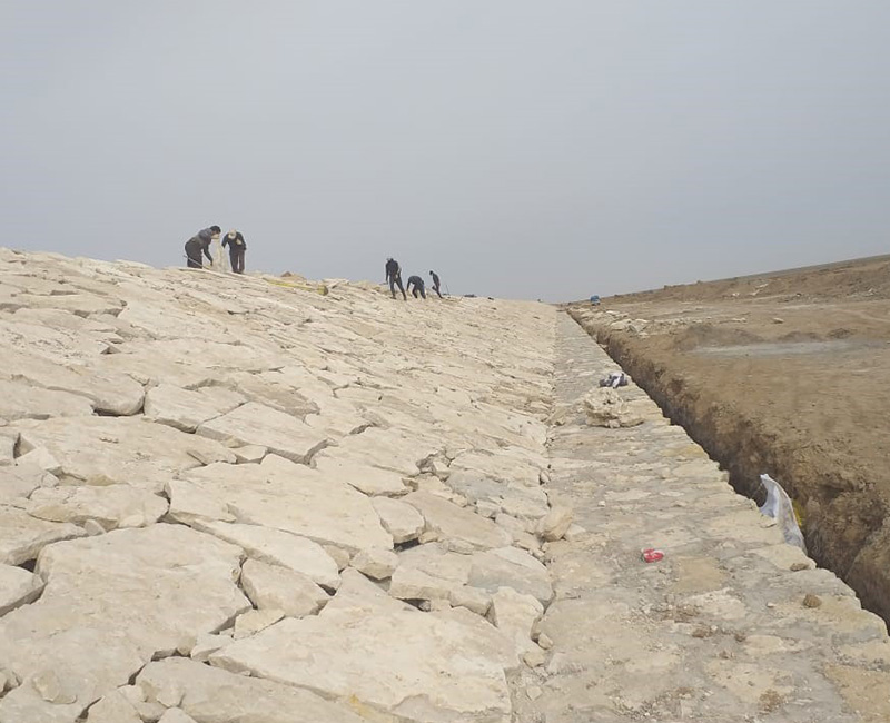 Earthworks and stone cladding for embankment A / Basra Governorate